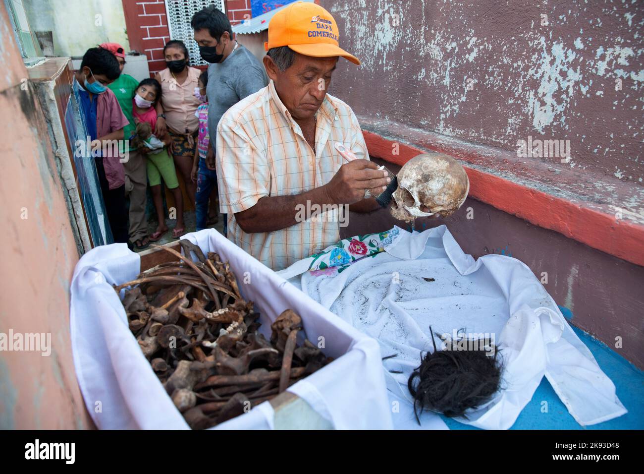 Don Venancio Tuz Chi, one of the administrators of the Pomuch cemetery, cleaning the bones and skulls of a deceased relative of the Colli Ycauch family at the cemetery of Pomuch, Campeche state, Mexico on October 22, 2022. Don Venancio has been a hired bone cleaner for over twenty years, he is paid $1.50 per skeleton. Every year in preparation for Hanal Pixán, the Mayan Day of the Dead celebration, members of the Pomuch community in southeastern Mexico extract bones from their niches and carefully clean them – an ancestral tradition seen as a gesture of love and a way to get closer to deceased Stock Photo