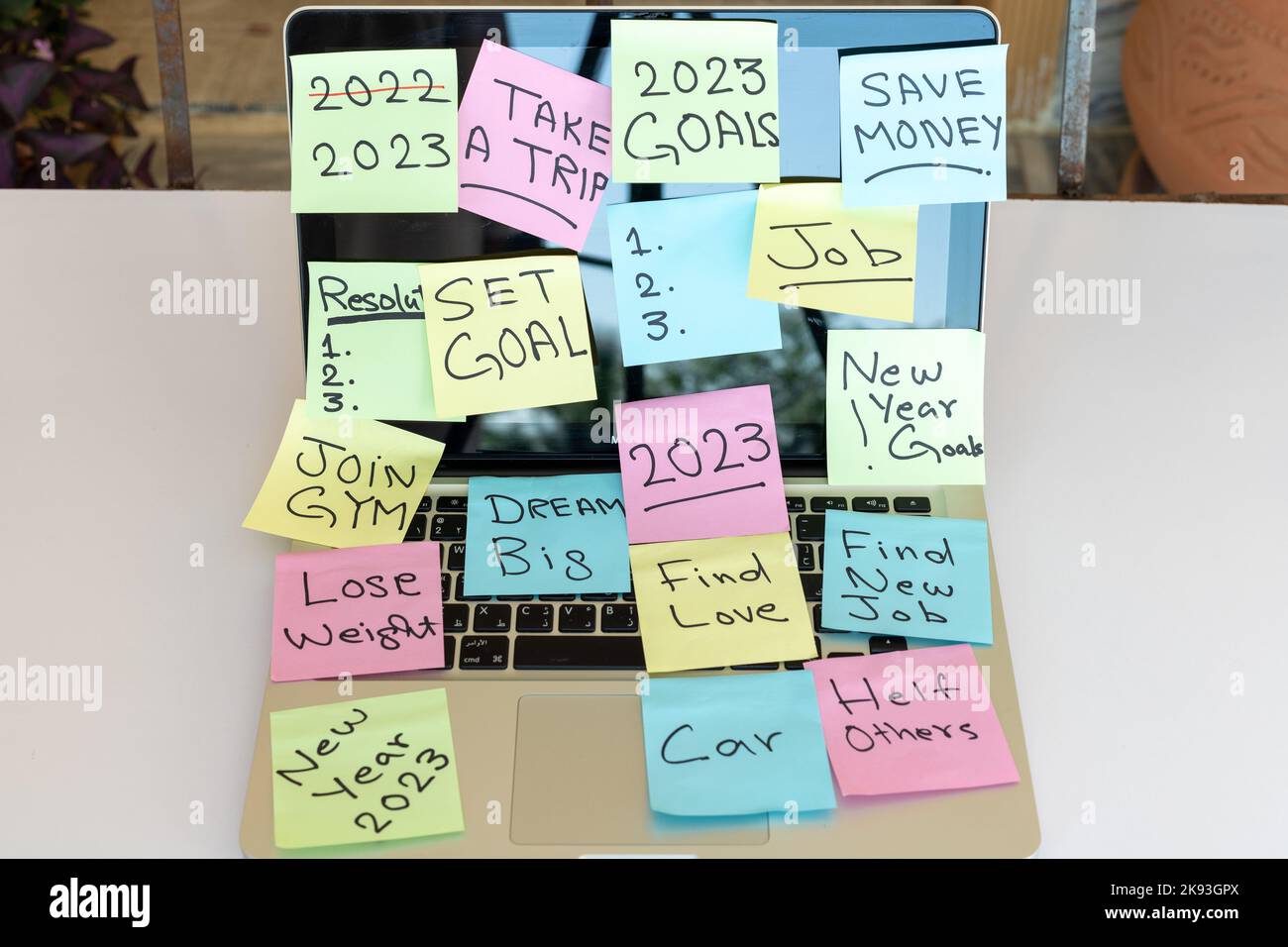 Colorful sticky notes with new year goals and resolutions pasted on a laptop Stock Photo