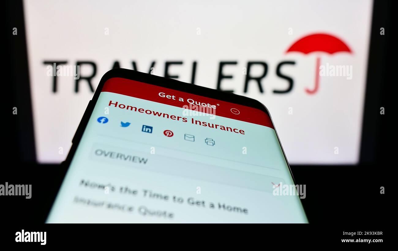 Smartphone with webpage of US insurance company The Travelers Companies Inc. on screen in front of logo. Focus on top-left of phone display. Stock Photo