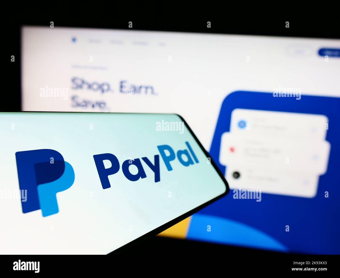 Smartphone with logo of American financial company PayPal Holdings Inc. on screen in front of website. Focus on center-left of phone display. Stock Photo