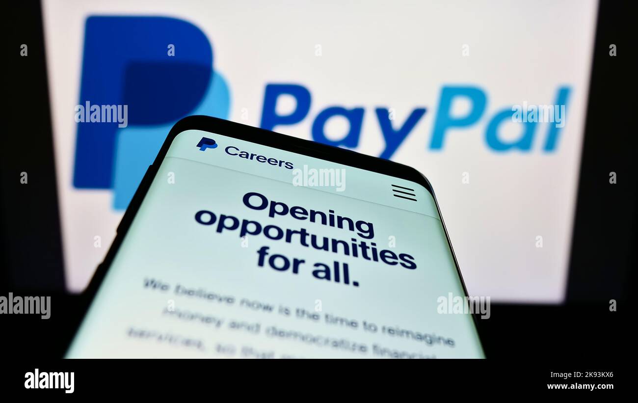 Mobile phone with website of US financial company PayPal Holdings Inc. on screen in front of business logo. Focus on top-left of phone display. Stock Photo