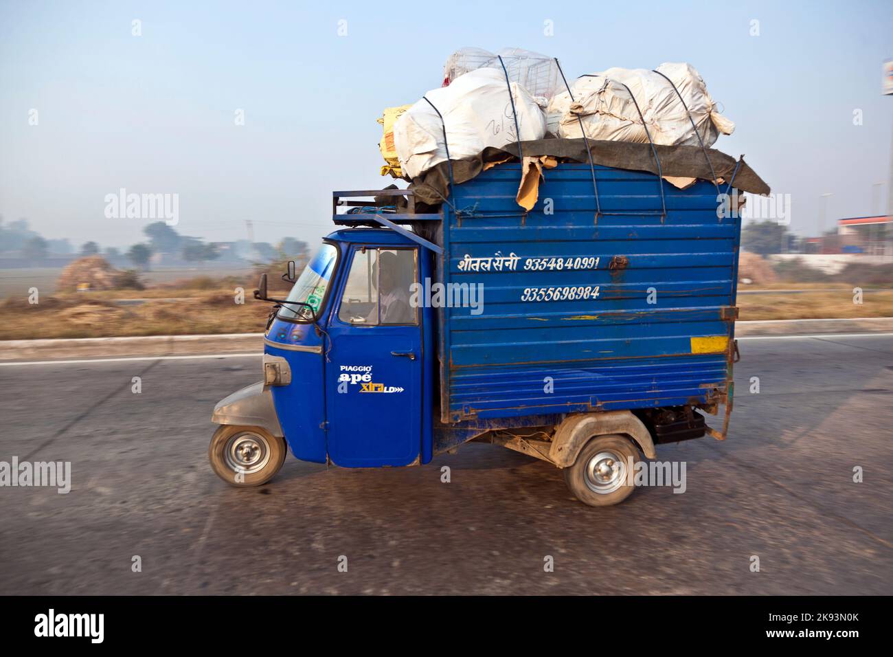 AGRA, INDIA - NOVEMBER 16:  overloaded rickshaw on the Highway on November 16, 2011 near Agra, India. NH2, a modern divided highway, connects the 200 Stock Photo