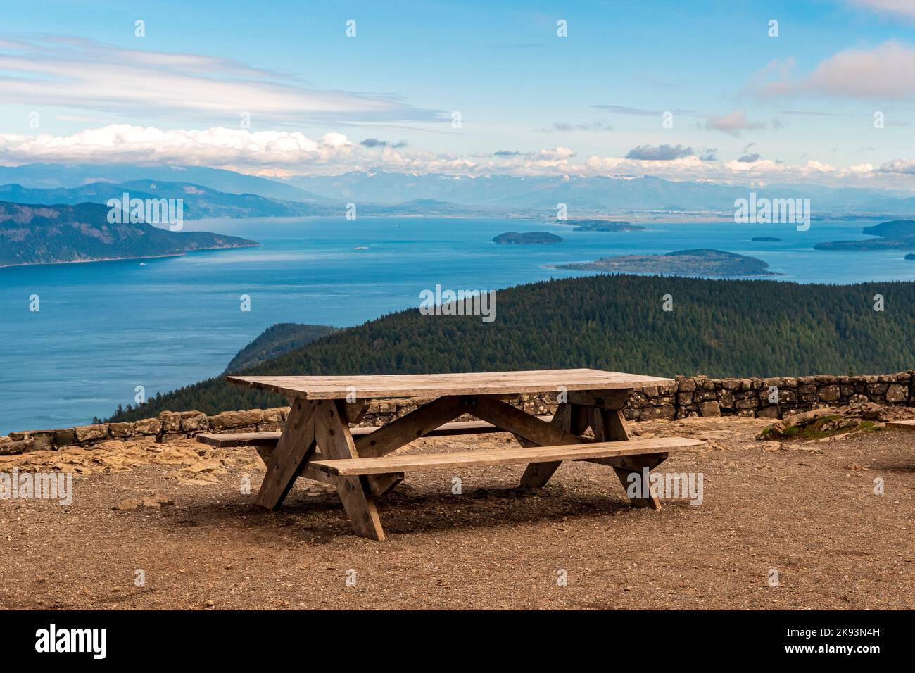 A picnic table with a view of the San Juan islands from the watch tower atop Mount Constitution on Orcas Island, Washington, USA. Stock Photo