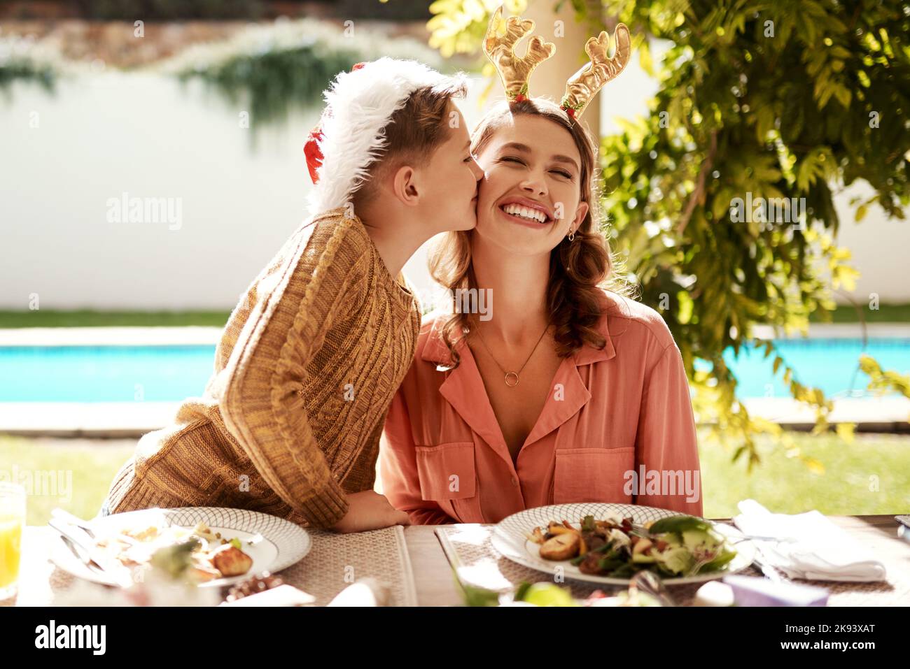 Christmas is all about appreciating your blessings. a girl girl and her mother enjoying Christmas lunch together. Stock Photo