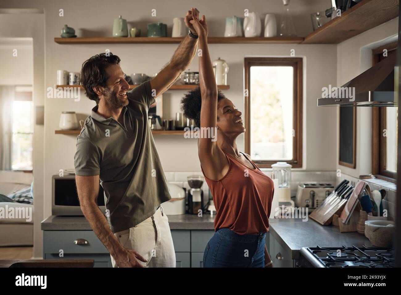 He loves dancing with his queen. an affectionate young couple dancing together in their kitchen at home. Stock Photo