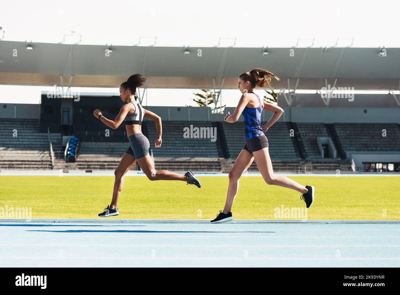 Closing the gap. Full length shot of two attractive young female athletes running along the track. Stock Photo