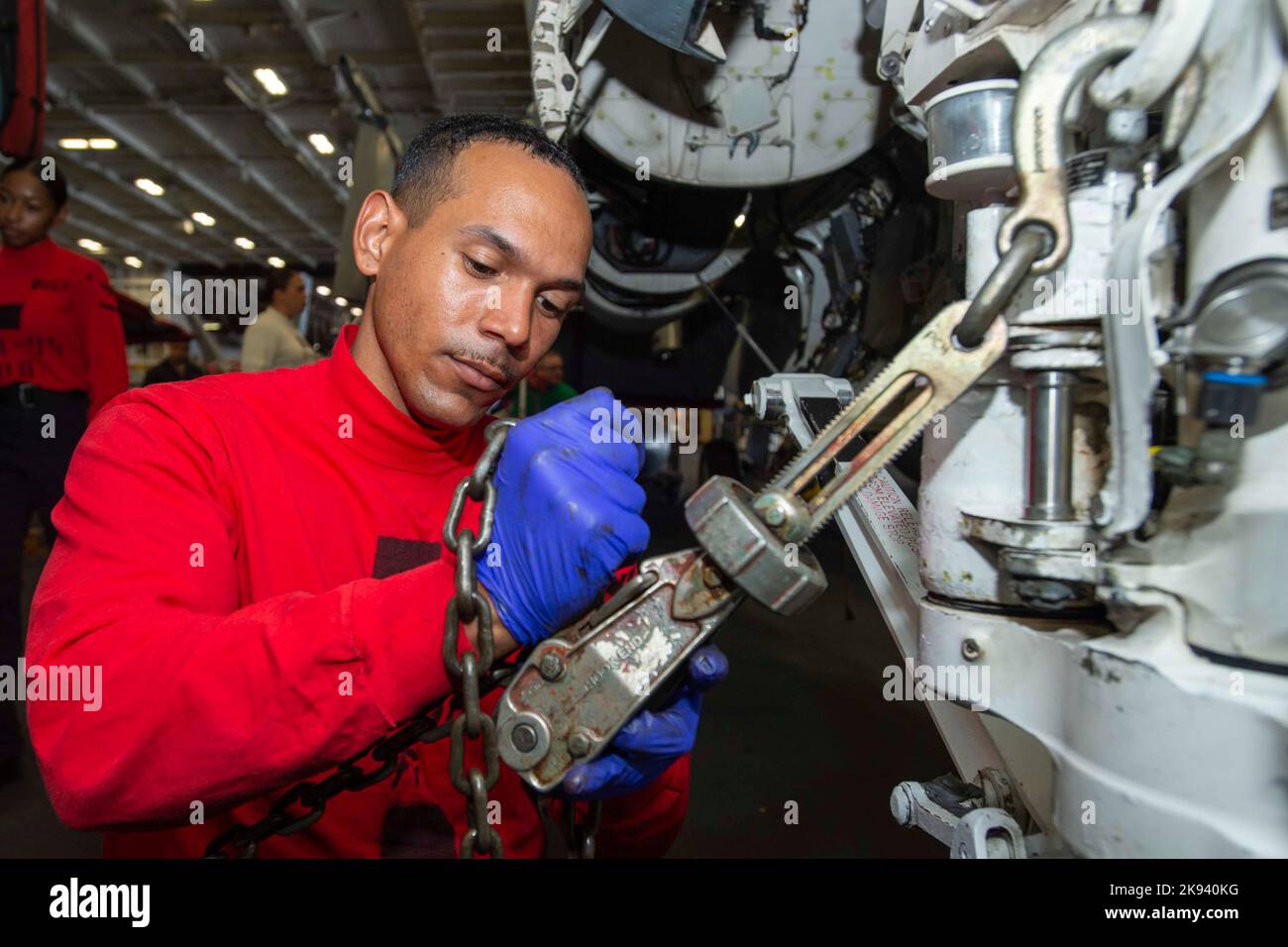 Pacific Ocean. 3rd Oct, 2022. U.S. Navy Aviation Ordnanceman 3rd Class Kevin Cross, from Los Angeles, removes chains from an F/A-18E Super Hornet, from the 'Mighty Shrikes' of Strike Fighter Squadron (VFA) 94, in the hangar bay aboard the aircraft carrier USS Nimitz (CVN 68). Nimitz Carrier Strike Group is underway preparing for an upcoming deployment. Credit: U.S. Navy/ZUMA Press Wire Service/ZUMAPRESS.com/Alamy Live News Stock Photo