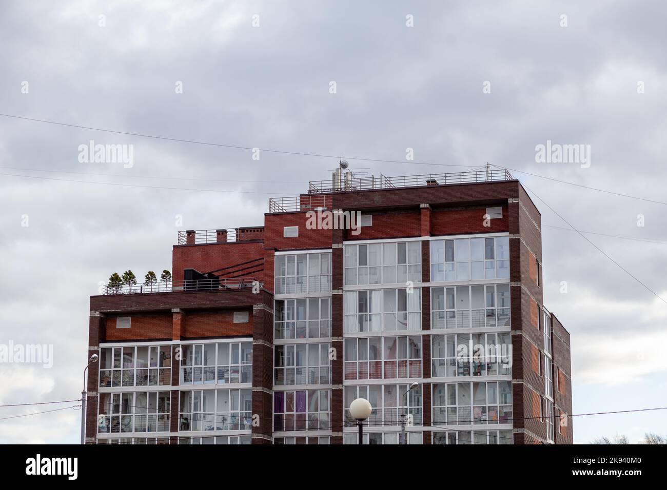 Windows of a residential multi-storey brick house. Modern buildings. The new multi-storey apartment brick building against the sky Stock Photo