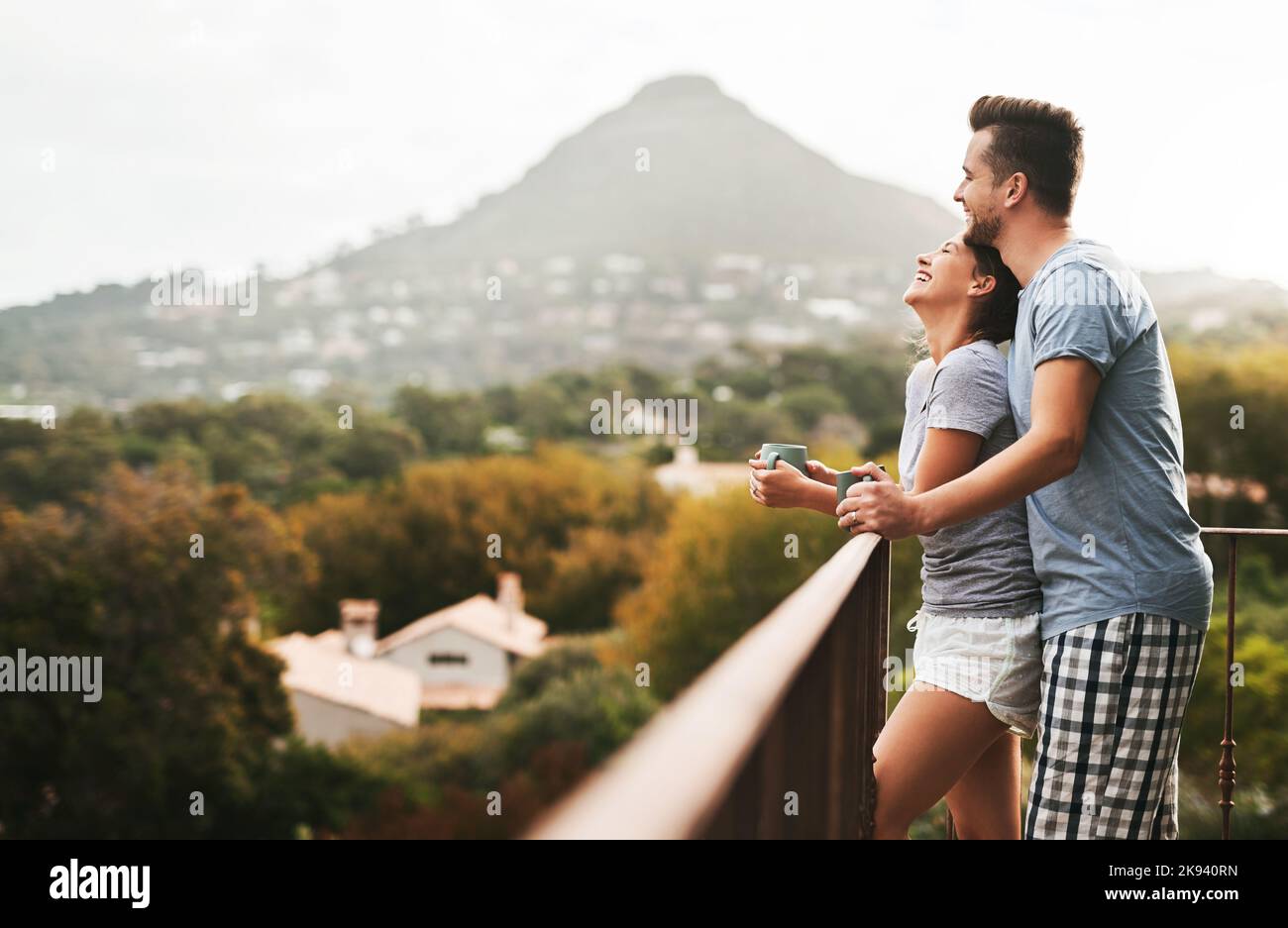We bring peace and happiness into each others lives. an affectionate young couple drinking coffee while standing on their balcony at home in the Stock Photo
