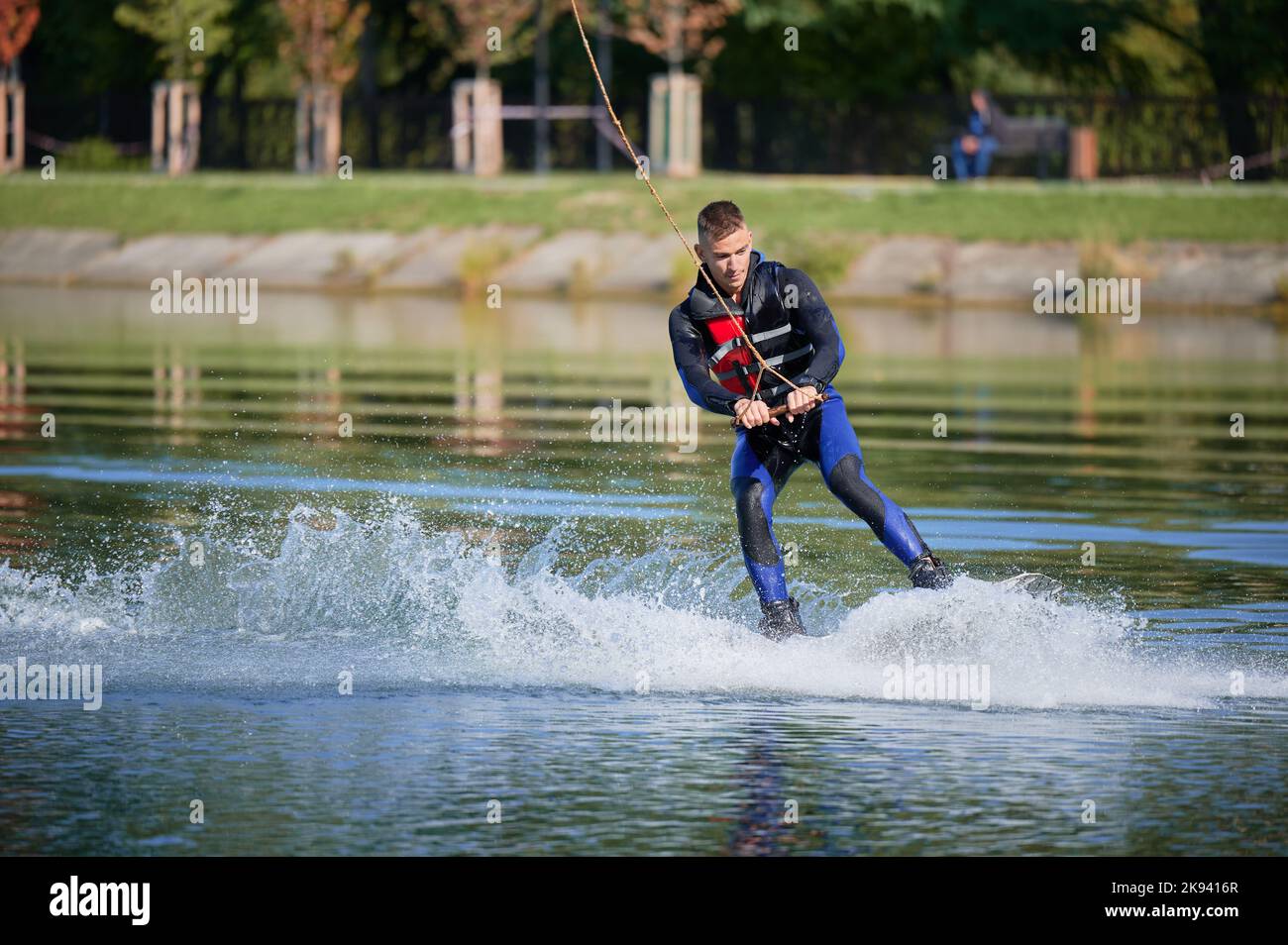 Wakeboarder surfing on lake. Young surfer having fun wakeboarding in