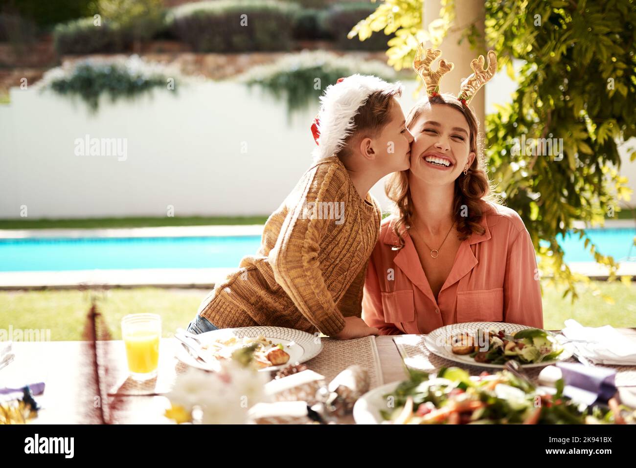 Love from family is all you need on Christmas. a girl girl and her mother enjoying Christmas lunch together. Stock Photo