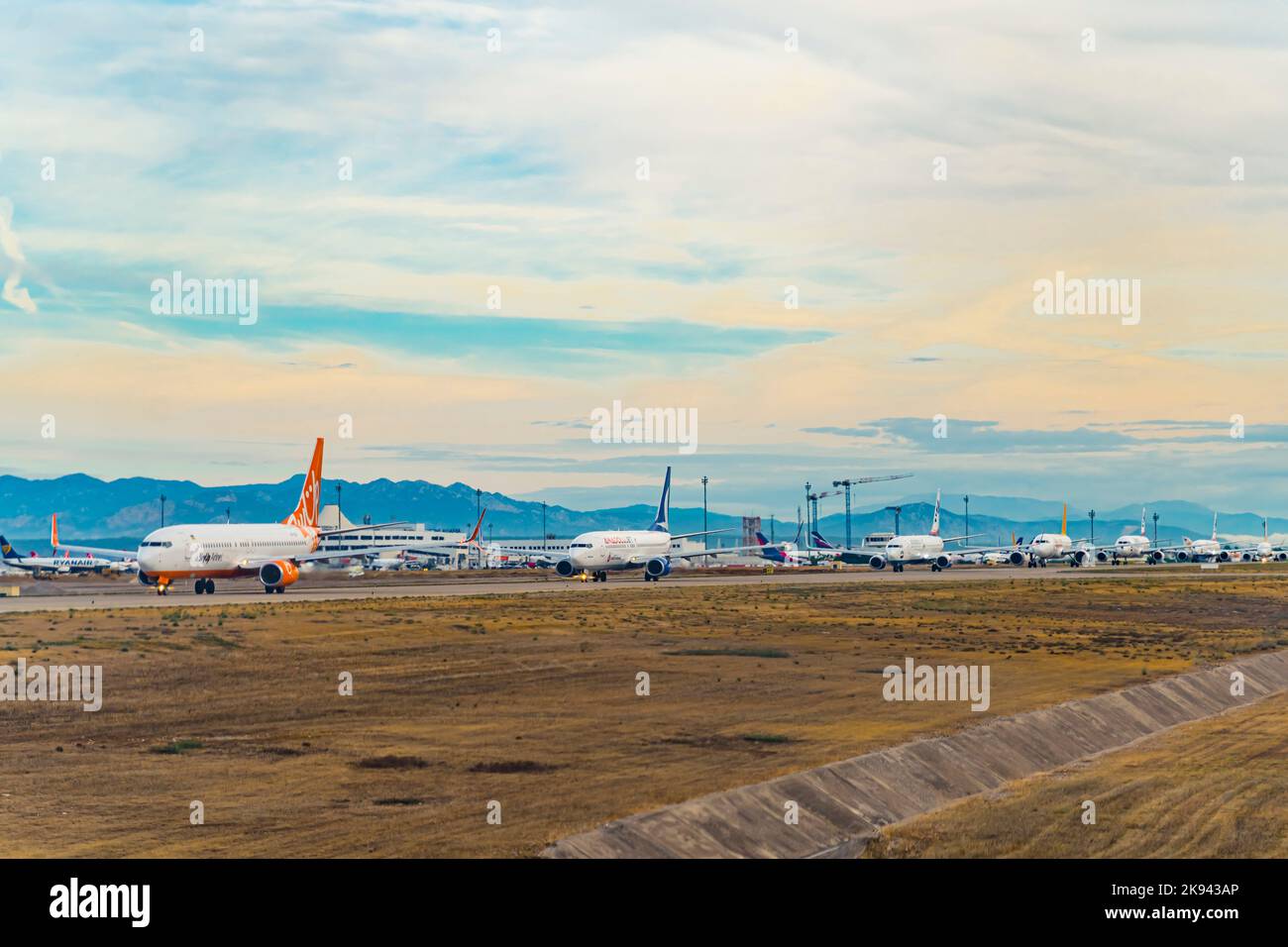10.12.2022 Antalya, Turkey - Delayed planes waiting in queue to the runway. beautiful blue mountains and blue sky in the background. High quality photo Stock Photo