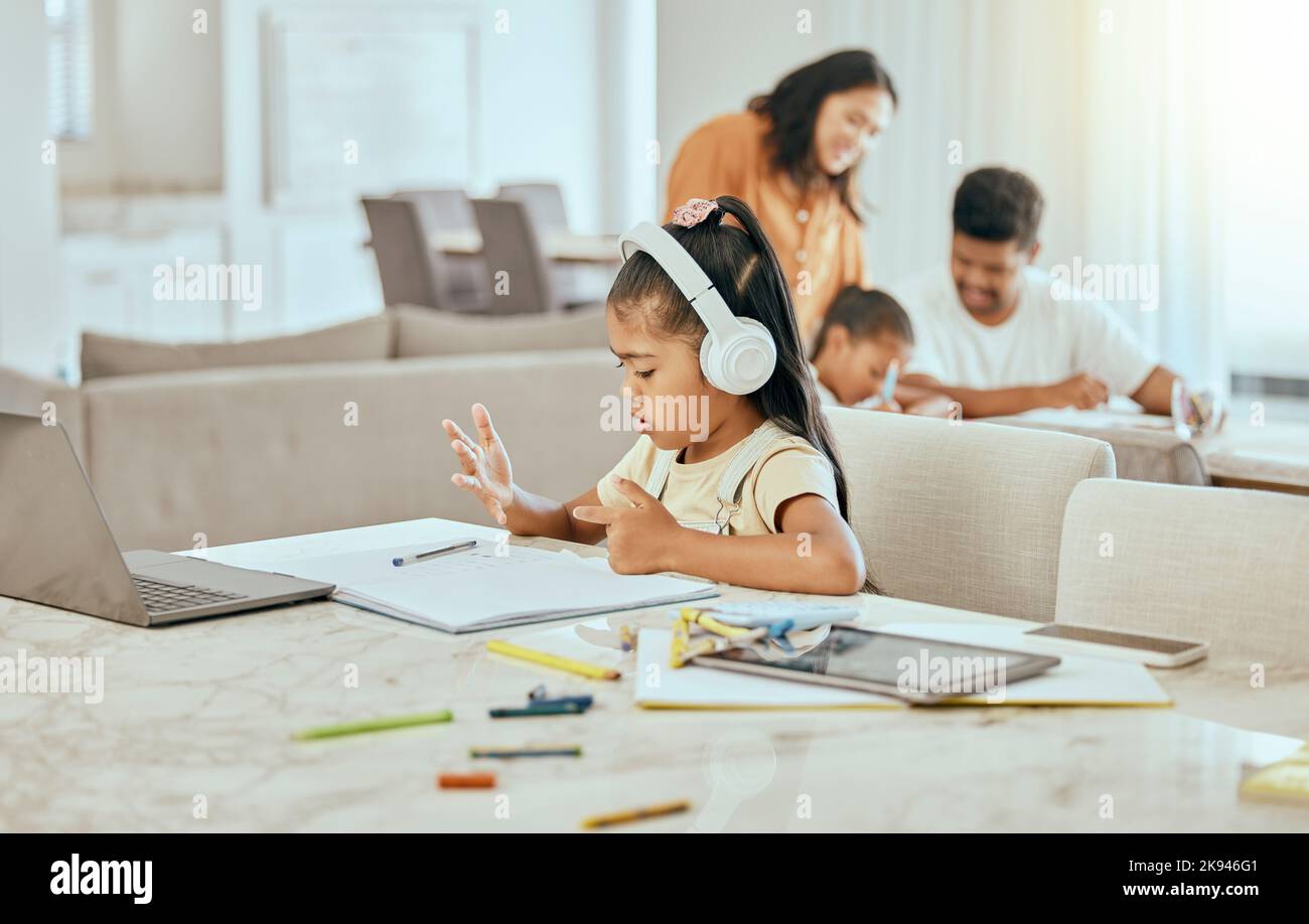 Child, hand and counting at desk with book for math, homework or education in home with family. Girl, laptop and fingers with headphones, computer or Stock Photo