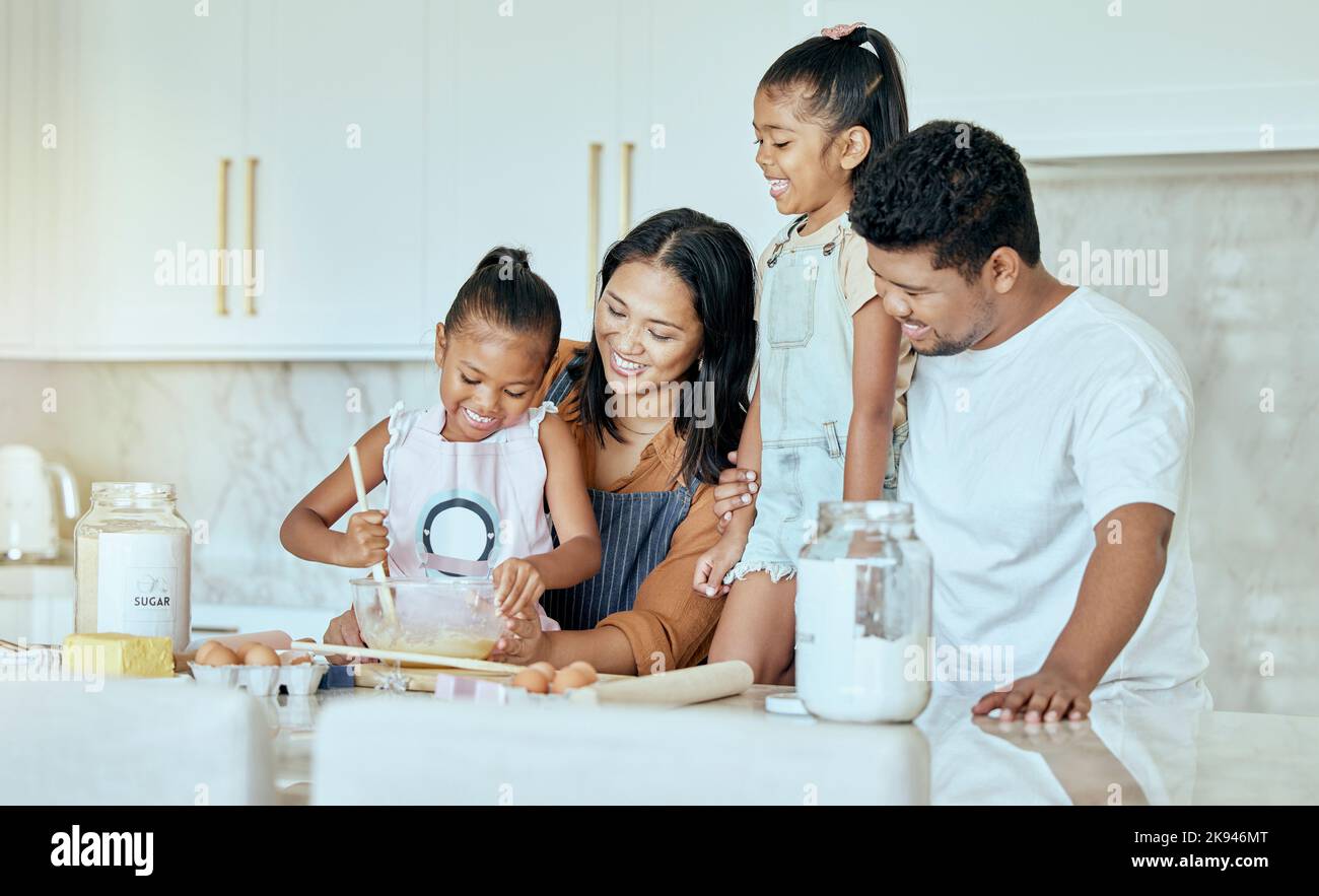 Happy, mother and father baking with children for family bonding, learning and teaching in the kitchen at home. Mama, dad and little girls helping Stock Photo