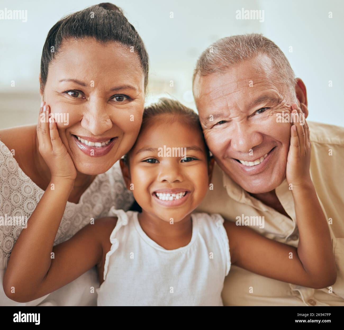 Family, portrait and face of girl with grandparents relax, bond and having fun in a living room, happy and content. Happy family, smile and child Stock Photo