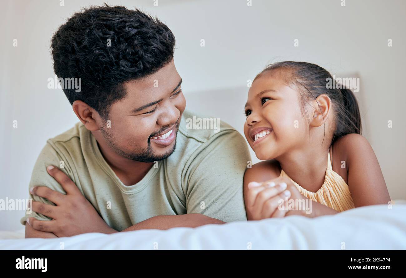 Father, child and family, together on bed and happy at family home, bonding and smile, spending quality time in bedroom. Filipino, man and girl, love Stock Photo