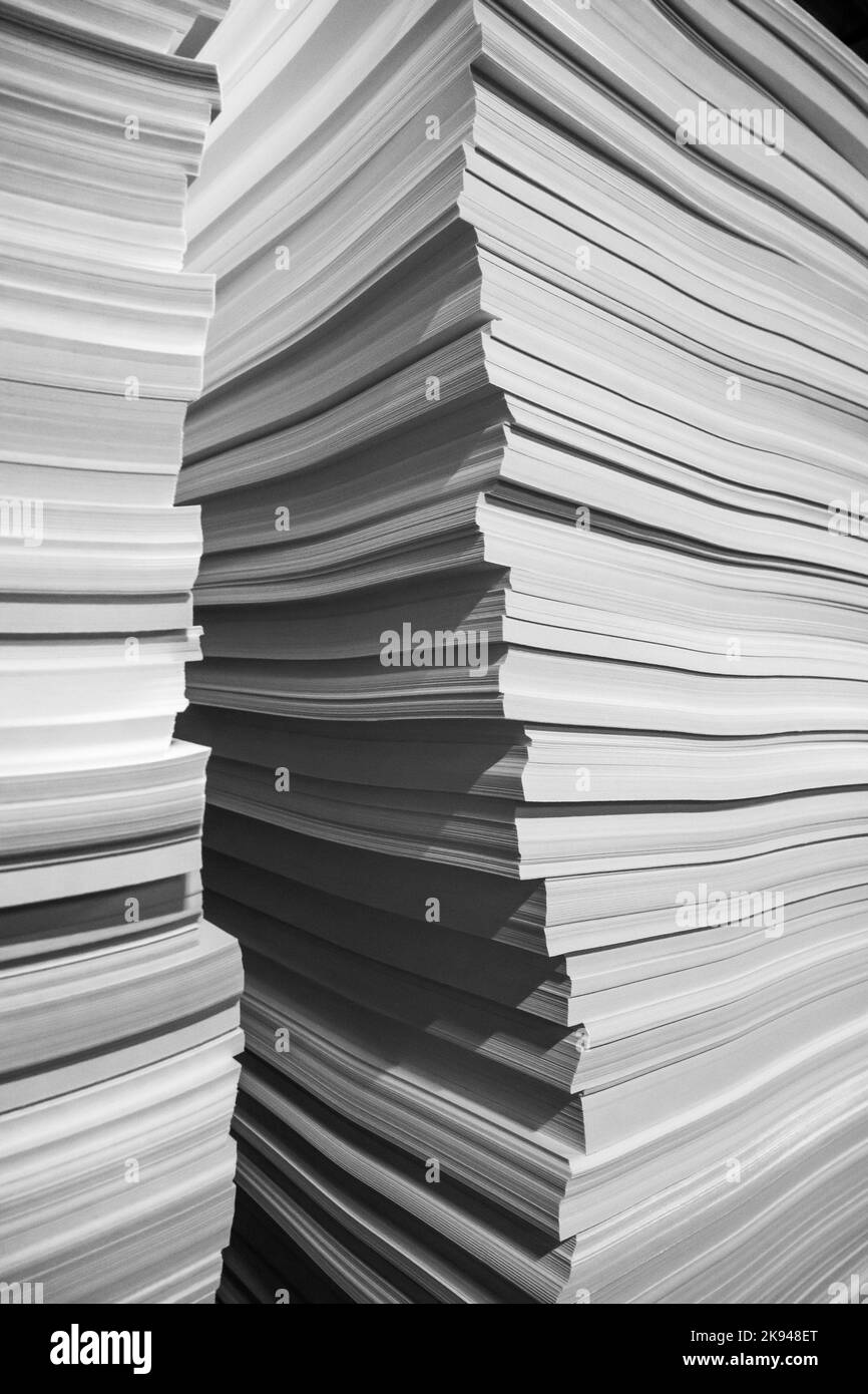 Blank sheets of white paper arranged in stacks during workday in modern