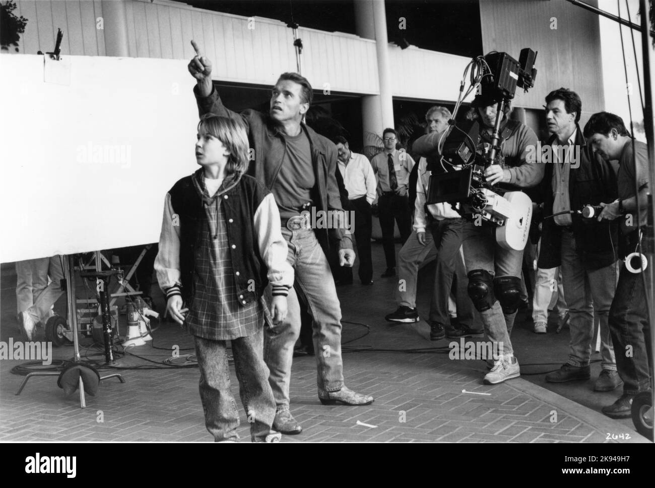 AUSTIN O'BRIEN ARNOLD SCHWARZENEGGER and Director JOHN McTIERNAN on set location candid with Movie Crew including Steadicam Operator MARK O'KANE during filming of LAST ACTION HERO 1993 director JOHN McTIERNAN music Michael Kamen Oak Productions / Columbia Pictures Stock Photo