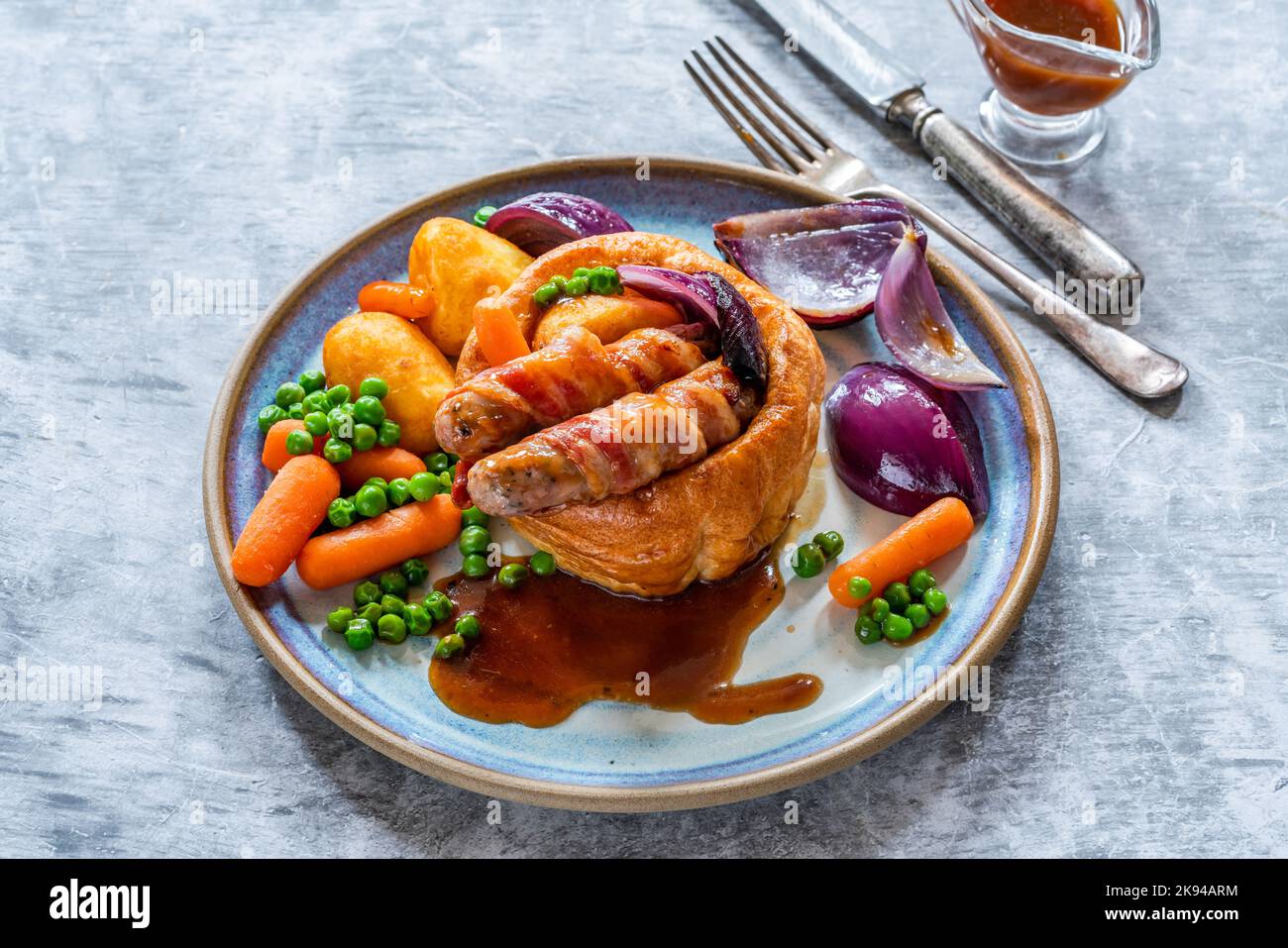 Toad in the hole with Yorkshire pudding, sausages and vegetables Stock Photo