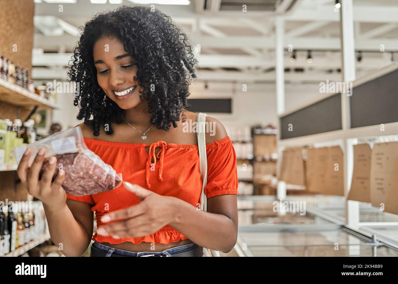 Customer, shopping and woman reading meat label of groceries, stock information and check cost price in retail supermarket store. Happy consumerism Stock Photo