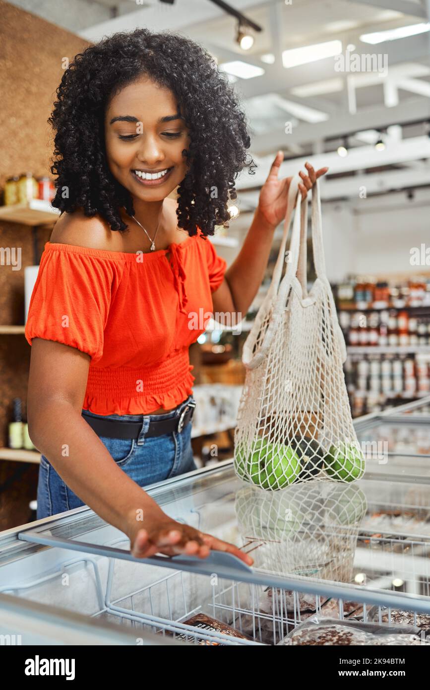 Shopping, grocery store and customer black woman with product price check in freezer and happy with discount, sale or promotion discount. Groceries Stock Photo