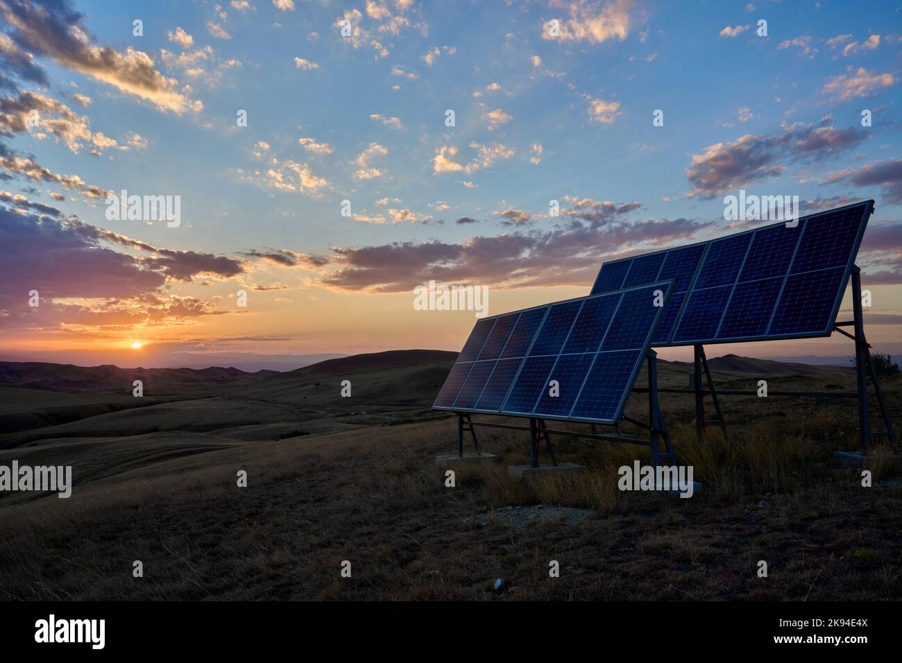 Sonnenuntergang, 2 Solarmodule neben einem Funkmast, Halbwüste, Steppenlandschaft Garedscha, Kachetien, Raion Sagaredscho, Südosten von Georgien Stock Photo