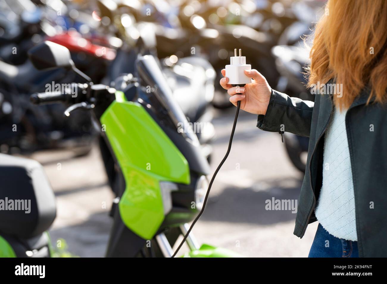 Charging an electric motorcycle in a city parking lot Stock Photo Alamy
