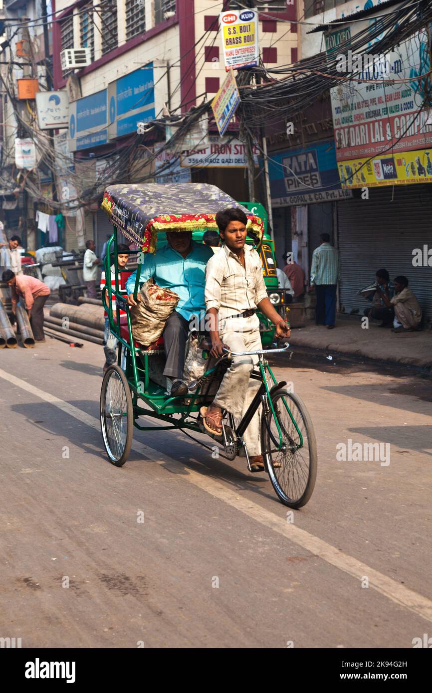 DELHI, INDIA - NOV 9: Rickshaw rider transports passenger early morning ...