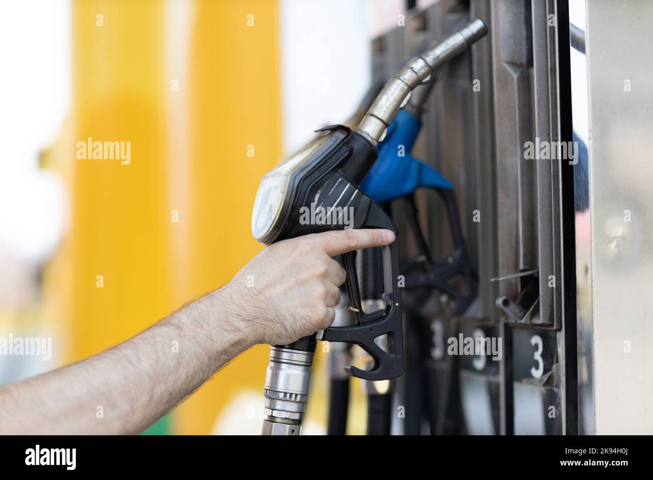 Man holding filling gun in his hand at gas station Stock Photo - Alamy
