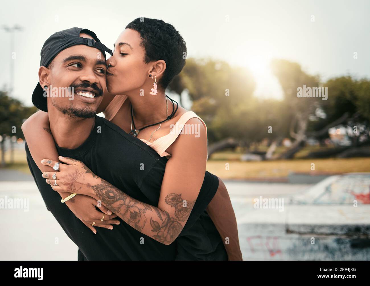 Black couple, hug and cheek kiss in city, affection or bonding together with smile. Love, romance and happy man and woman enjoying quality time Stock Photo
