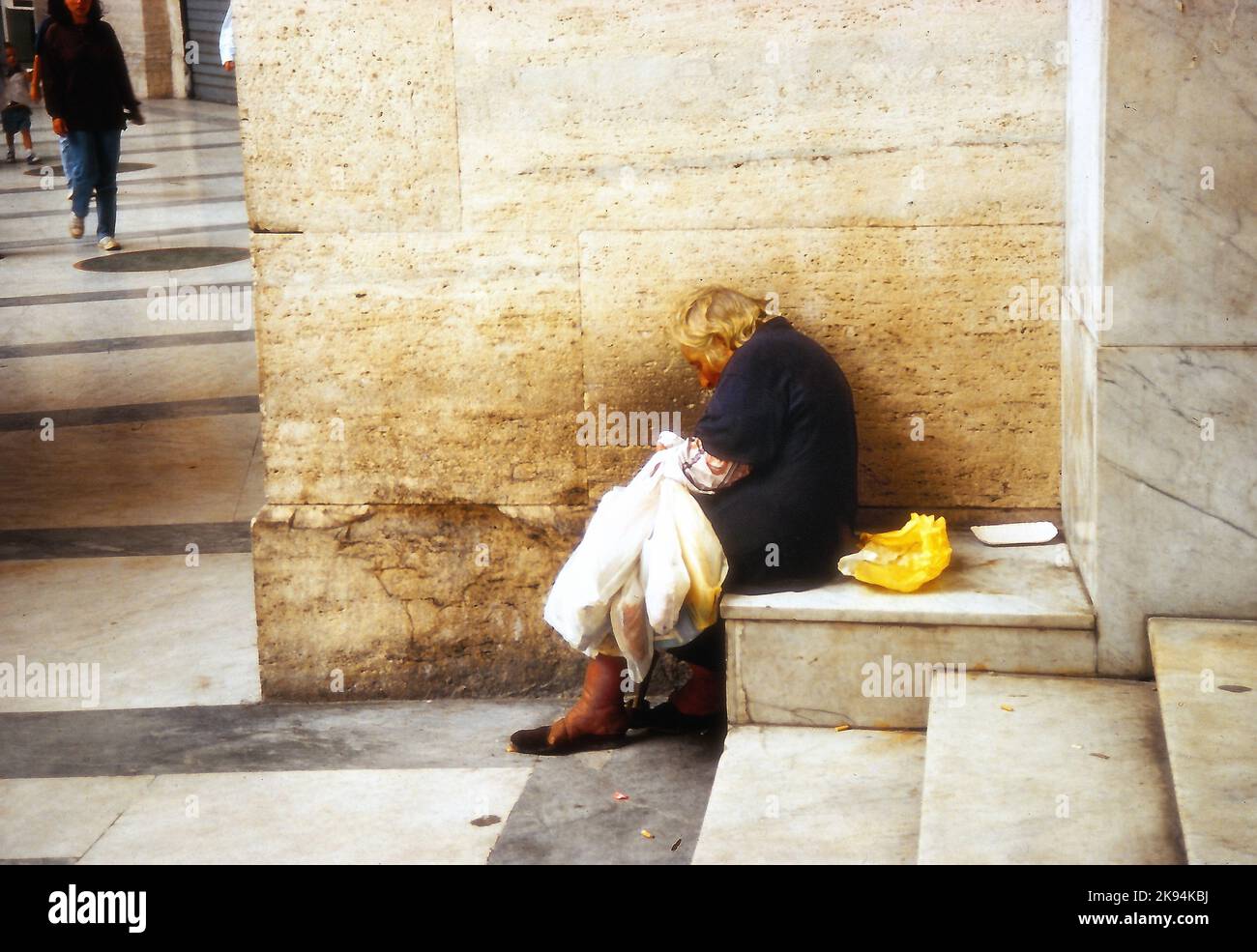 Naples 1985, an old homeless woman sleeps on the steps of the Galleria Umberto Primo, an important shopping gallery. Stock Photo