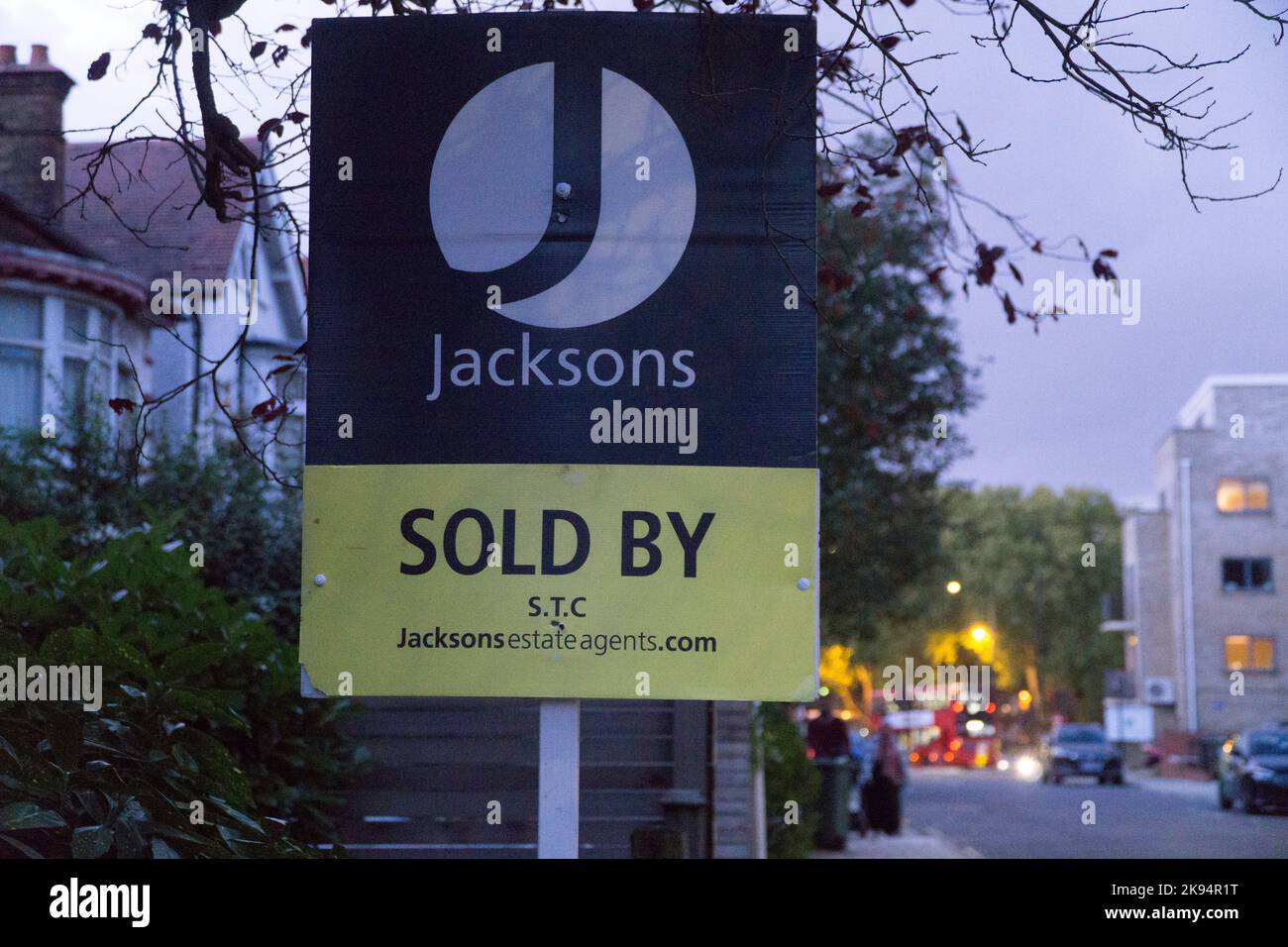 London, UK, 24 October 2022: An estate agent's 'For Sale' sign outside a house in Clapham at dusk. High interest rates and the cost of living crisis are likely to cause a downturn in the housing market. Anna Watson/Alamy Live News Stock Photo