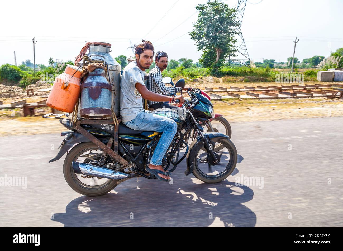 RAJASTHAN, INDIA - OCTOBER 18: men riding motorbike with cans of milk on October 18, 2012 in Rajasthan, India. These motorized milkman reach also the Stock Photo
