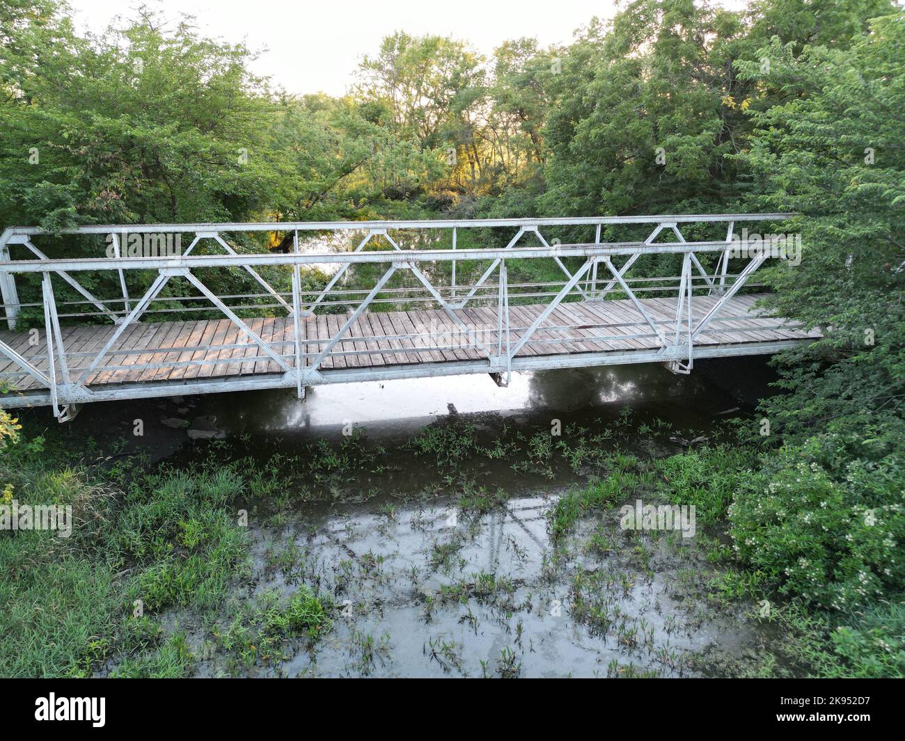 A grey steel bridge over the river surrounded by trees Stock Photo - Alamy