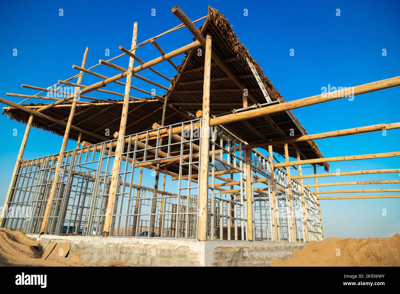 A Steel structured frame work of a building under construction supported by wooden beams Stock Photo