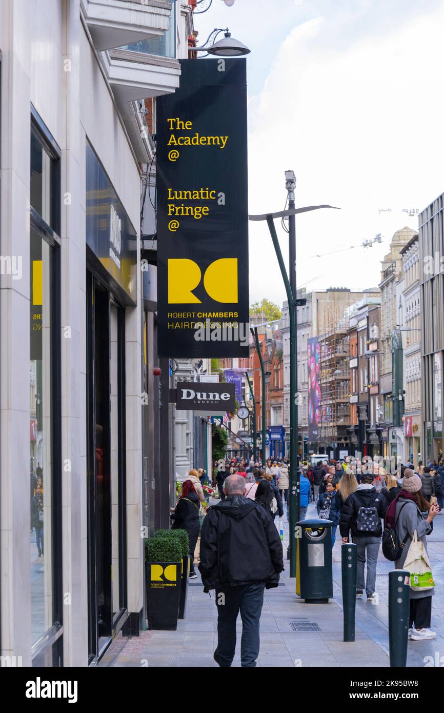 Ireland Eire Dublin Grafton Street pedestrian street scene signs The Academy@ Lunatic Fringe@ Robert Chambers Hairdressing shoppers tourists crowds Stock Photo