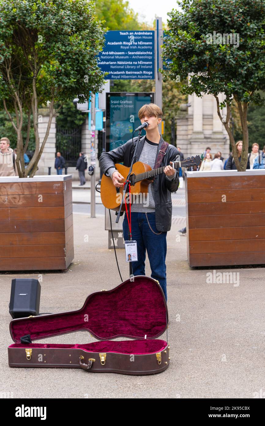 Ireland Eire Dublin Grafton Street busker solo young youth musician guitar singing playing licensed street performer Uisco Jones ear nose ring Stock Photo