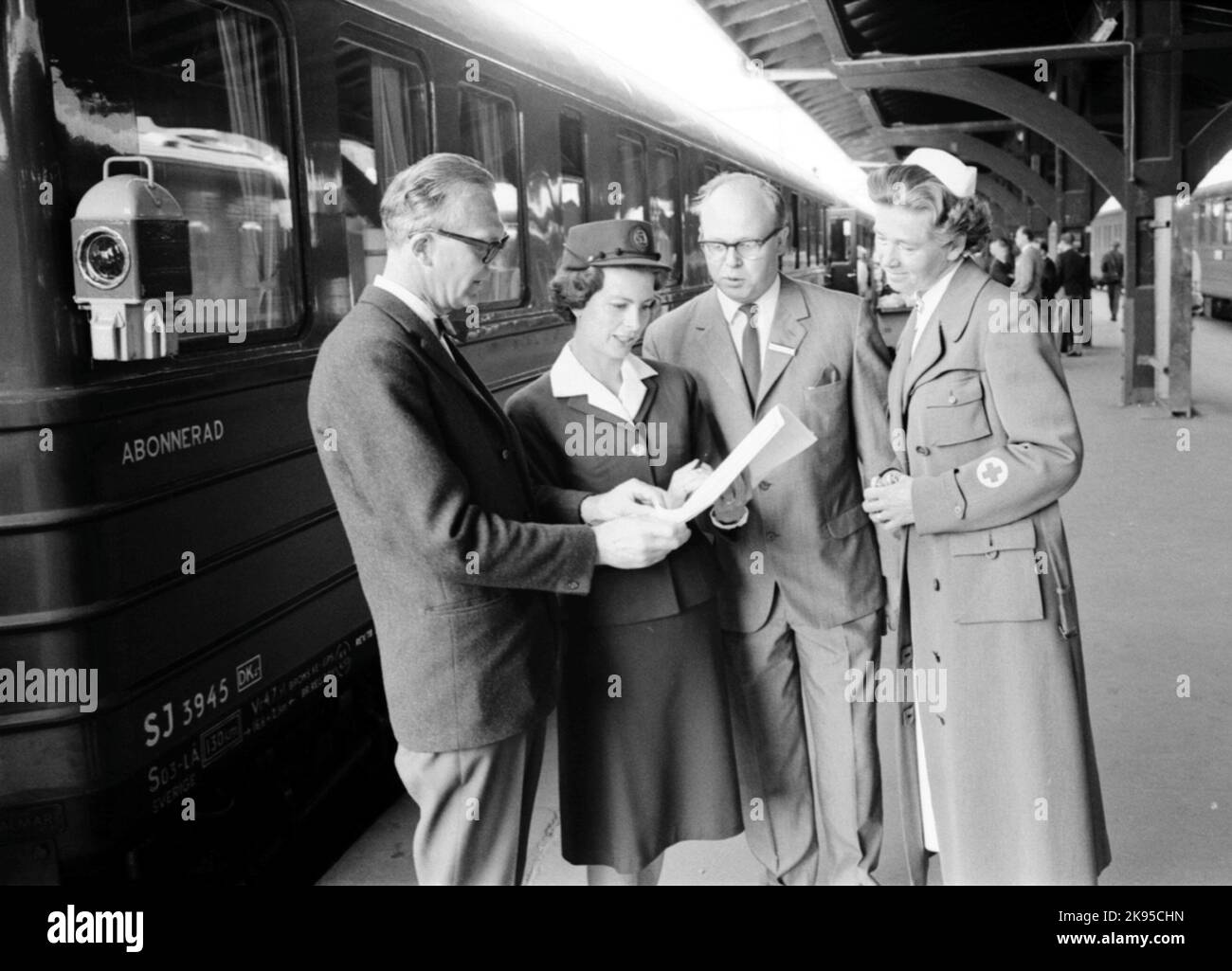 Departure of the first trip on the 'Sunlit Nights Land Cruises' (SNLC) (Dollaråget) from Central Station. Conscarriage State Railways SJ S0 3945. Two officials, a train hostess and a nurse, have a review before departure. Stock Photo