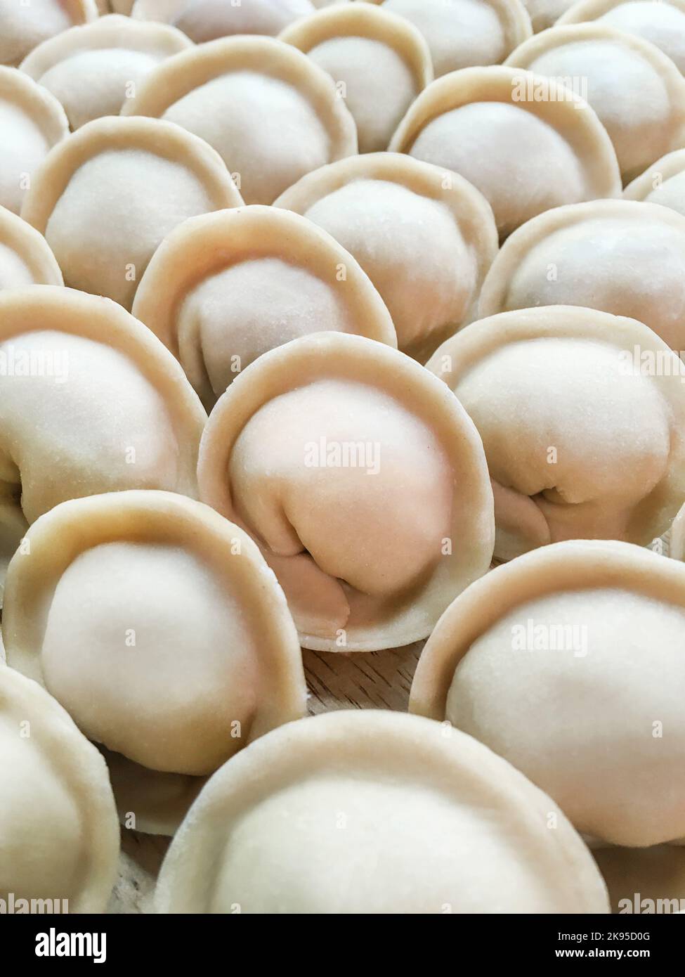 Full frame photo of meat pelmeni. Rows of handmade raw dumplings, traditional Russian food. Stock Photo