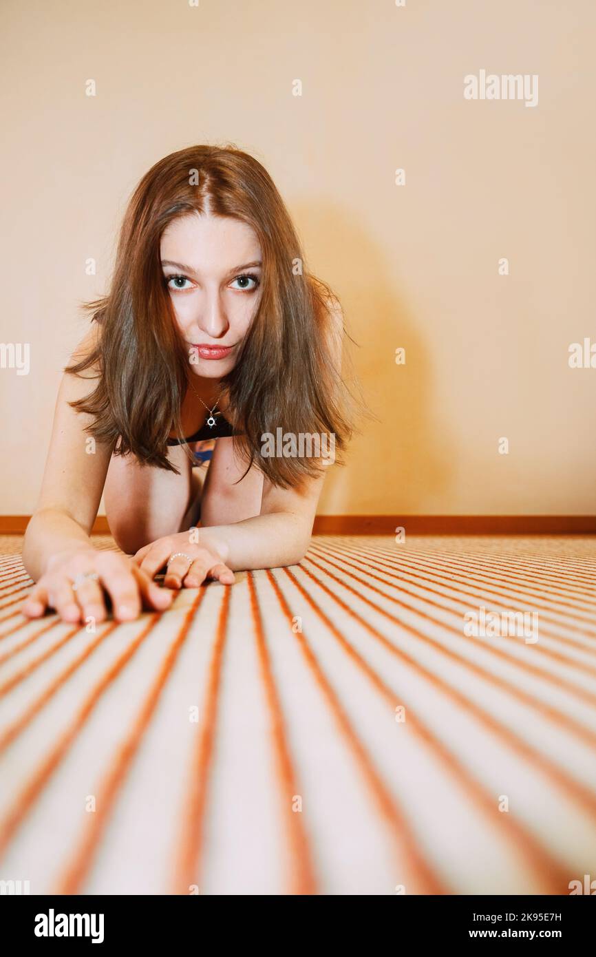 Pretty girl crawling towards us on striped carpet Stock Photo