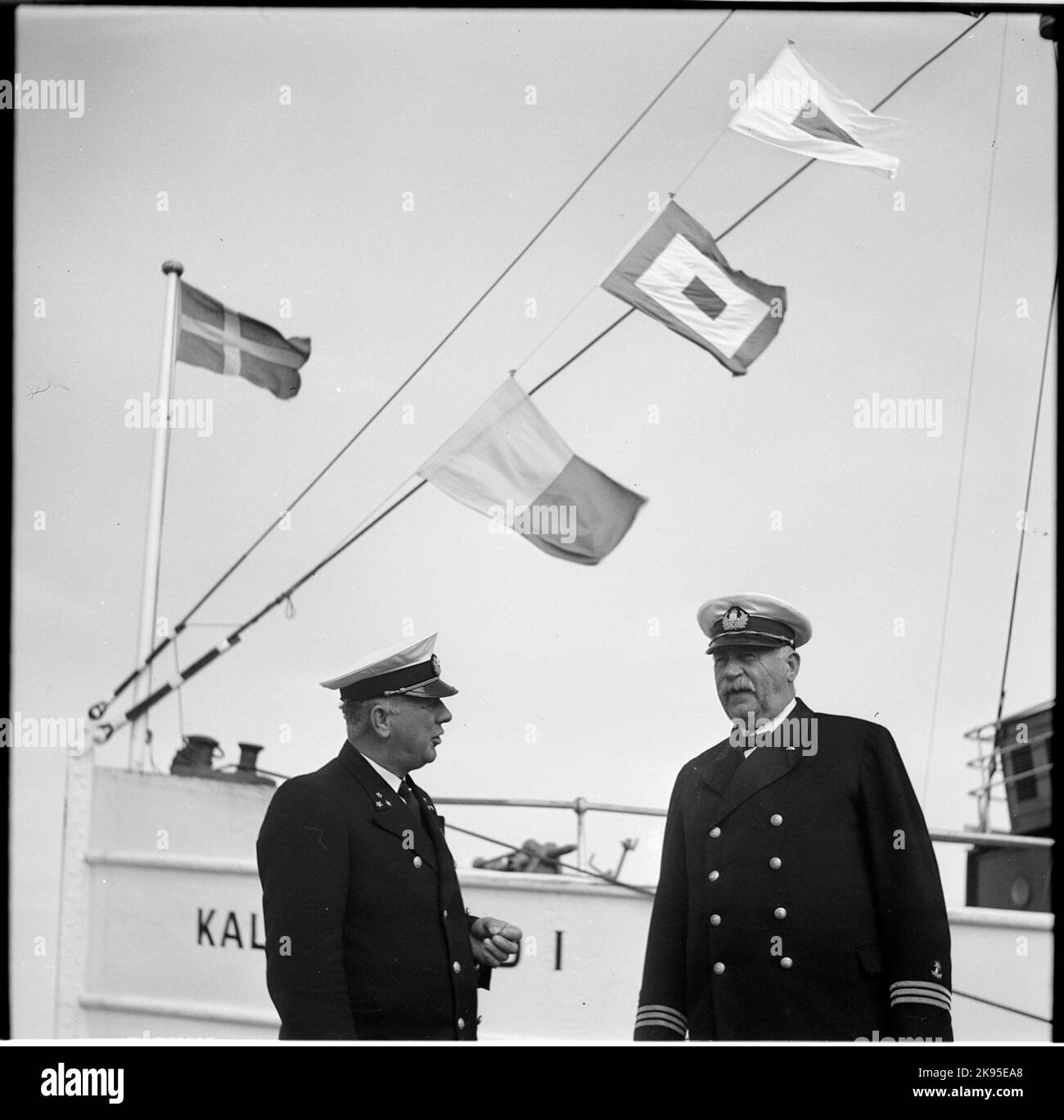 Two ship captains on the quay. In the background, M/S Kalmarsund I. Stock Photo