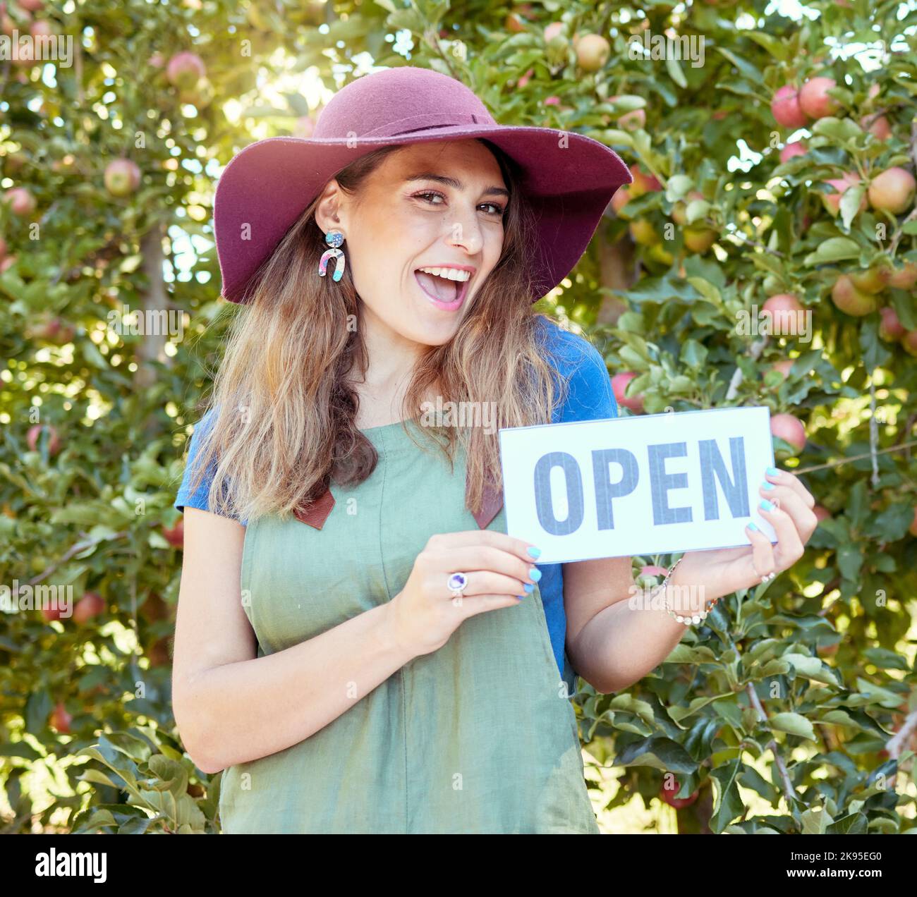 Woman, fruit farm and open store sign of a happy entrepreneur for agriculture and apple orchard. Female manager proud and success smile with Stock Photo