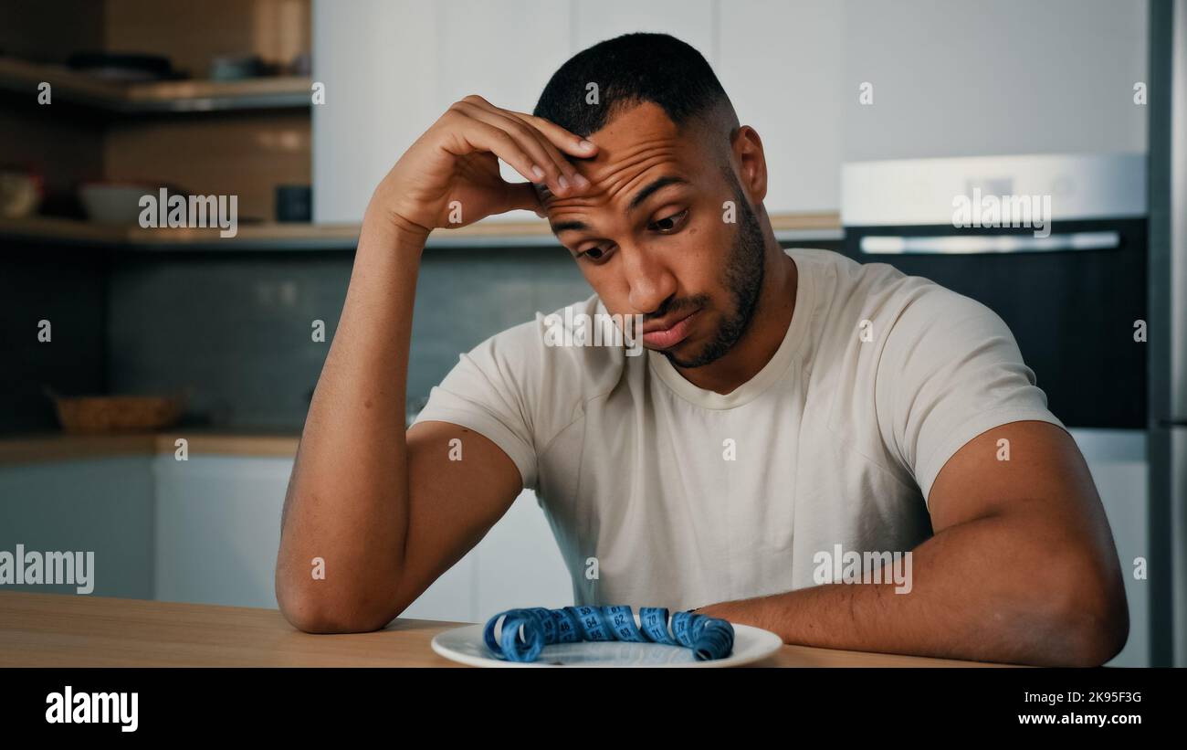 Sad disappointed failure unhappy African sports man sporty guy Latino male dissatisfied with body shape lost weight growth muscular dieting nutrition Stock Photo