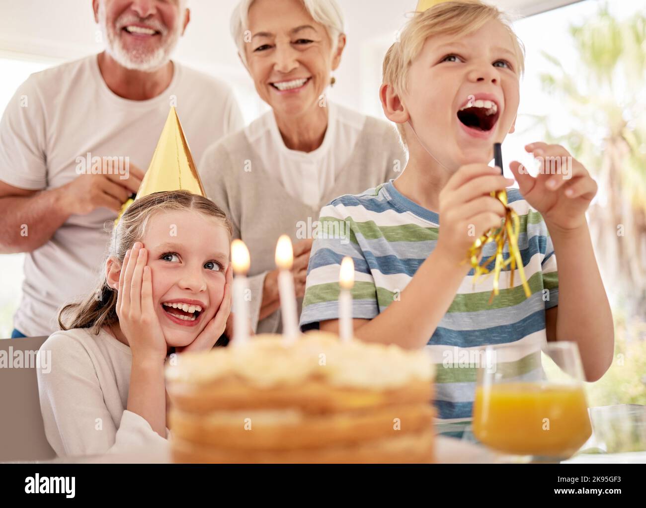 Happy birthday, family and girl with a cake in a party celebration with grandparents and excited sibling or brother. Smile, happiness and young child Stock Photo