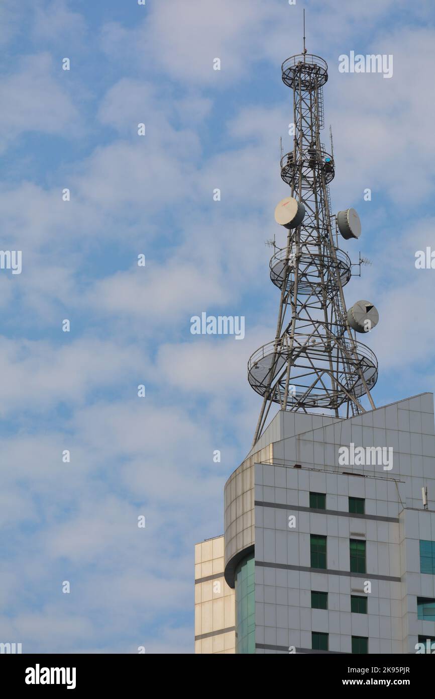 Communication mast above a Chinese media company. Dishes for local radio and television. Stock Photo