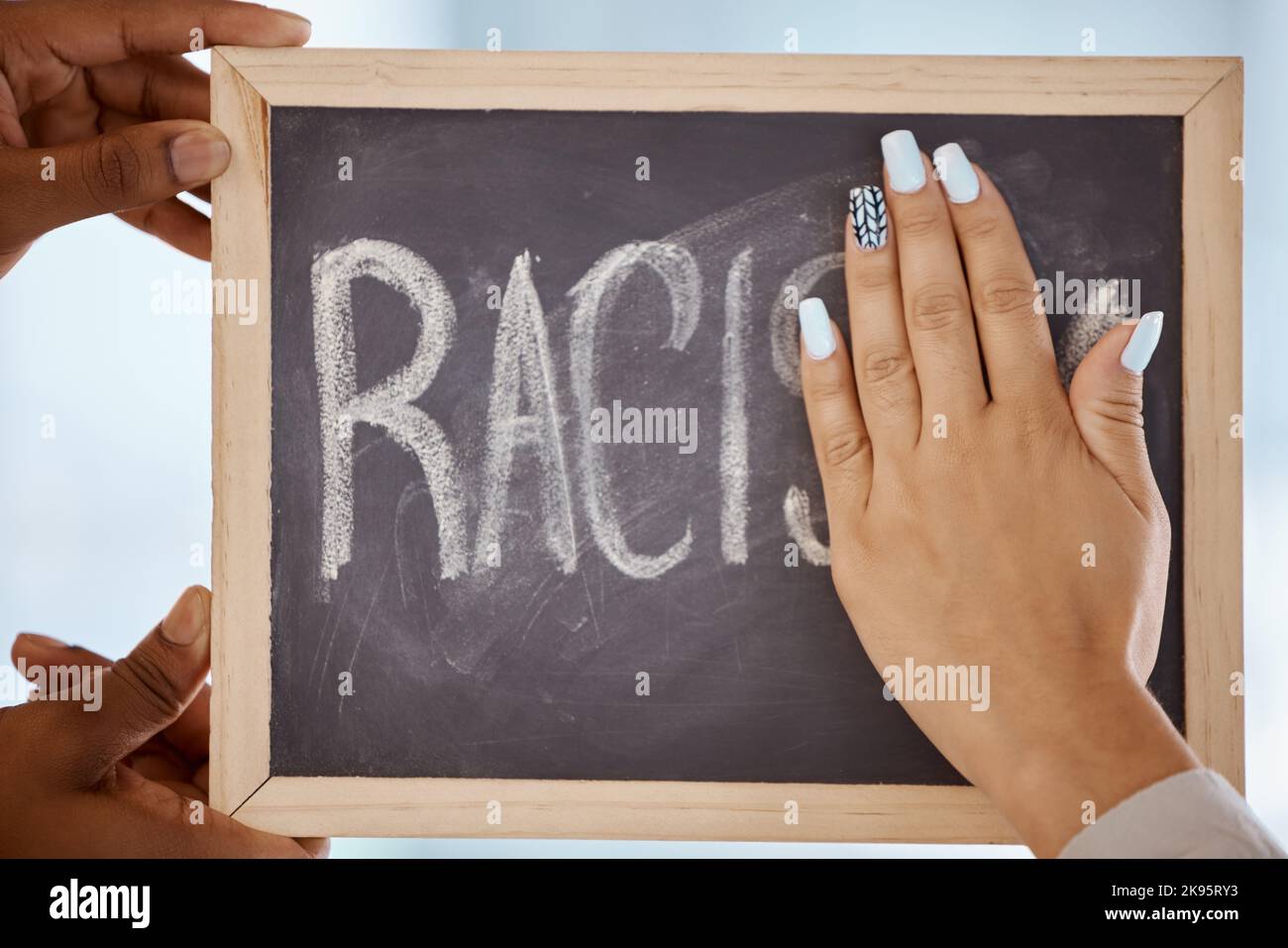Racism, protest and stop hands on blackboard to remove inequality writing for a change in society. Race, prejudice and black lives matter group Stock Photo