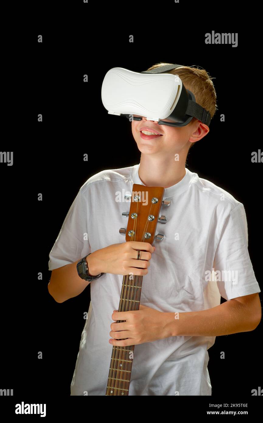 Boy playing guitar game in virtual reality helmet. VR googles, glasses
