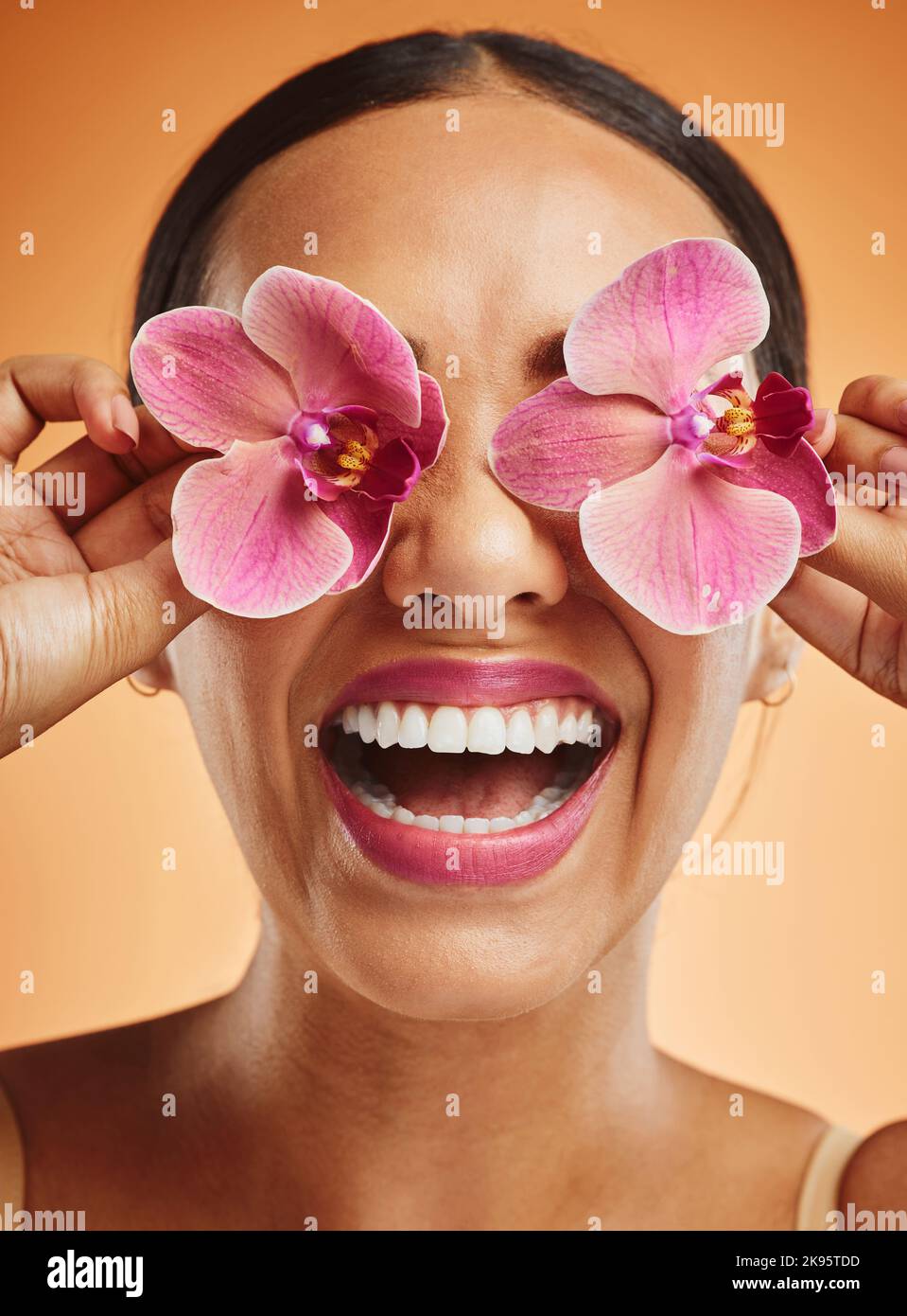 Skincare, beauty and flowers on face of woman for spa wellness, health and beauty products. Creative, facial and happy girl with orchid over eyes for Stock Photo