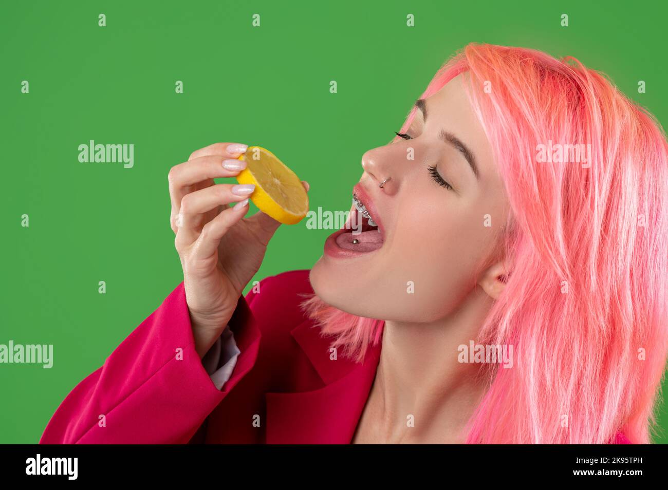 Girl eating the lemon slice in front of the camera Stock Photo