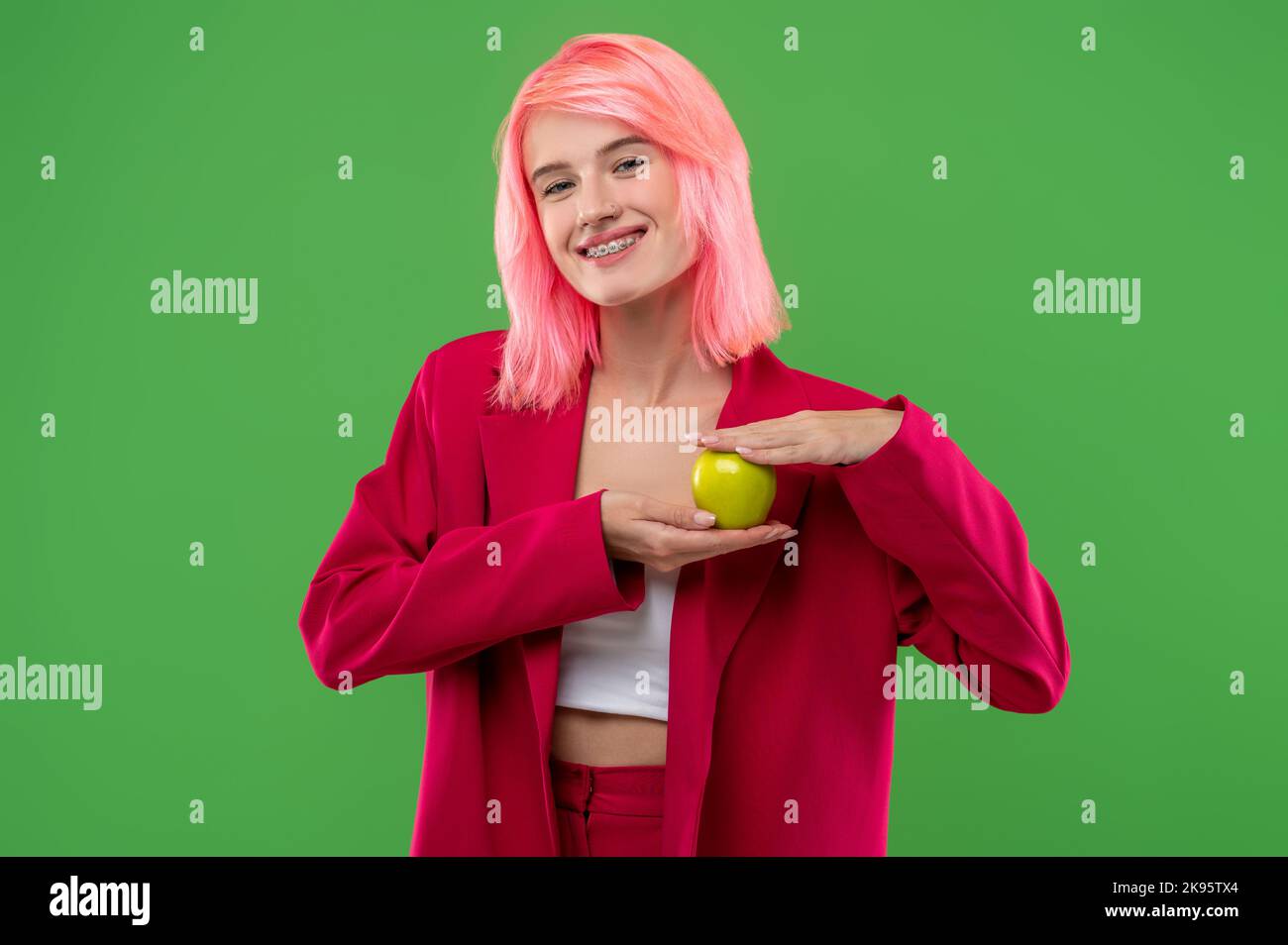 Joyous young woman demonstrating her favorite fruit before the camera Stock Photo